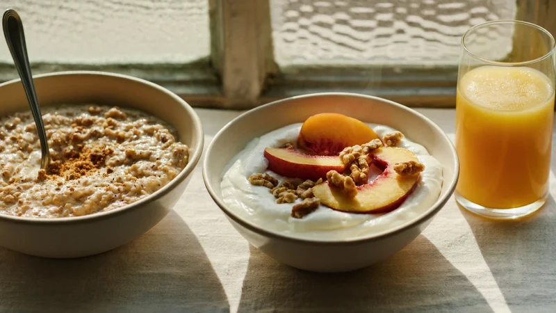 Yogurt con pesche e noci accanto a porridge d'avena sul davanzale soleggiato